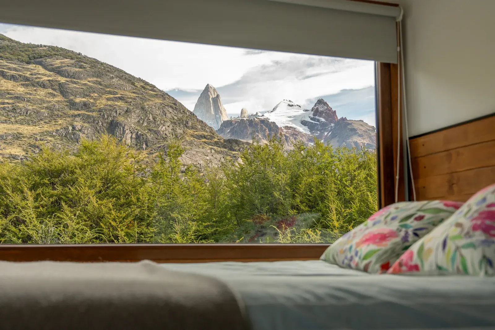La cama frente al ventanal, con el Fitz Roy encendido por el sol