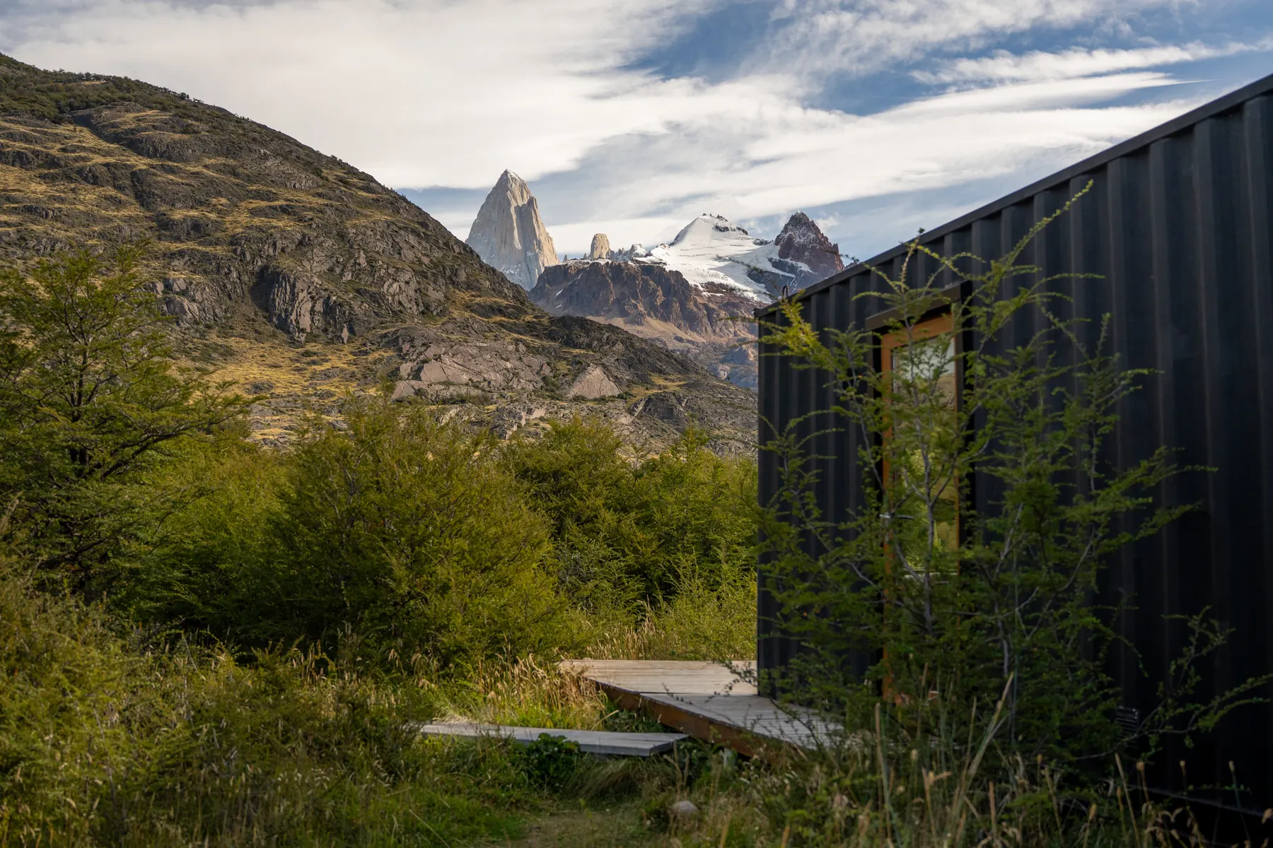 El Fitz Roy detrás de una de las casas, con el bosque alrededor